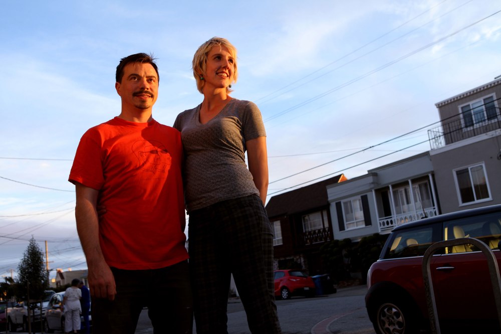 Owners Michael McCrory and Lauren Crabbe stand in front of Andytown Coffee Roasters as the sun sets on the western half of San Francisco. 